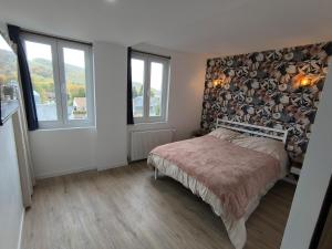 a bedroom with a bed and a wall of logs at Les petits gaillards in Les Andelys
