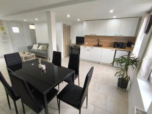 a kitchen and dining room with a black table and chairs at Les petits gaillards in Les Andelys
