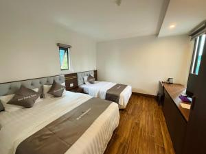 une chambre d'hôtel avec deux lits et une fenêtre dans l'établissement Hải Đăng Hotel, à Hàm Yên