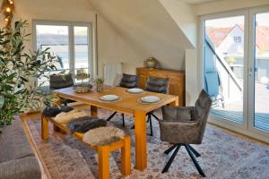 a dining room with a wooden table and chairs at Ferienwohnung Heidrun Kalkau in Kleinengstingen +7 photos