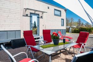 einen Tisch und Stühle auf einer Terrasse mit einem Haus in der Unterkunft Tiny House Ingo John in Sandstedt