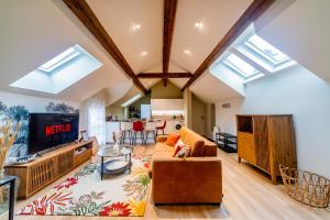 a living room with a couch and a tv at Le Céleste - Parking Privatif - Terrasse - Netflix in Ballan-Miré