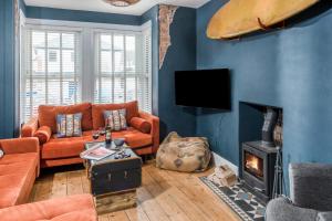 een woonkamer met een bank en een open haard bij The Bunker House in Newquay