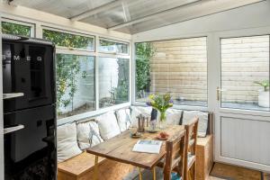 een eetkamer met een tafel en een koelkast bij The Bunker House in Newquay +13 foto's