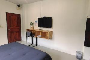 een slaapkamer met een bed en een tv aan de muur bij Samed Hotel in Ko Samed