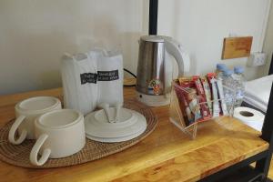 een aanrecht met een koffiezetapparaat en kopjes erop bij Samed Hotel in Ko Samed +15 foto's