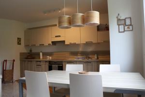 a kitchen with a white table and white chairs at Forest View Apartment in Pohorje