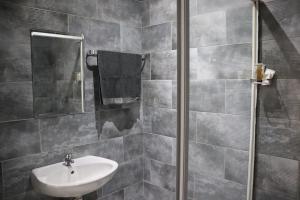 a bathroom with a sink and a mirror at Glow Events & Guest House in Centurion +14 photos