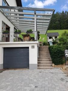 a house with a garage door and a staircase at Kienzler's Zeitwerk in Schonach