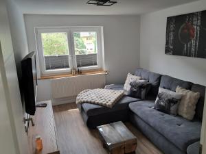 a living room with a couch and a window at Kienzler's Zeitwerk in Schonach