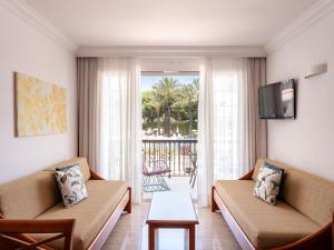 a living room with two couches and a tv at Inturotel Sa Marina in Cala d´Or