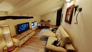 a living room with a couch and a television at Loft el Pasaje Secreto in Solórzano