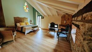 a bedroom with a bed and a stone wall at Loft el Pasaje Secreto in Solórzano