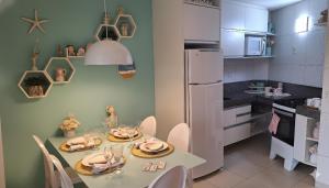 a dining room with a table and a kitchen at CARNEIROS BEACH RESORT AP 311 E in Praia dos Carneiros