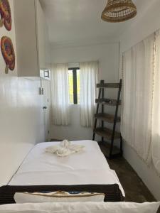 a bedroom with a bed with a towel on it at Lone Traveler Beach View Room in Caridad