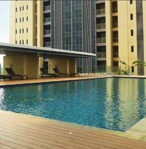 una piscina di fronte ad alcuni edifici alti di Art Inspired Apartment at Branz BSD 1BR a Samporo