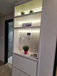 una mensola con piante in vaso in una stanza di Art Inspired Apartment at Branz BSD 1BR a Samporo