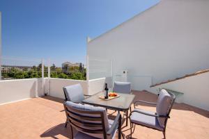 a patio with a table and chairs on a balcony at Casa Soalheira - Tavira Center in Tavira