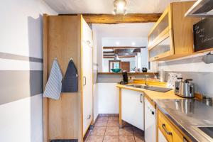 a kitchen with wooden cabinets and a counter top at Fachwerk-Ferienhaus 1764 in Eslohe