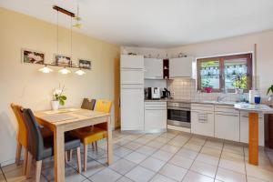 a kitchen with a wooden table and a dining room at Unterm Nussbäumle in Adelhausen