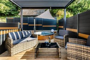 a patio with two wicker chairs and a table at Love Room La Courtisane - Spa in Niederbronn-les-Bains