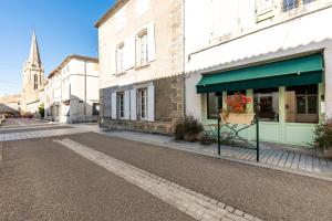 an empty street with a building and a church at Gite Des Lys in Monségur