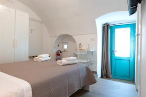 a bedroom with a bed and a blue door at Suite Le Cementine in Mottola