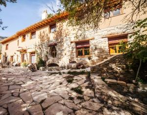 an old stone house with a stone courtyard at Molino Del Machero in Puebla de Don Fadrique