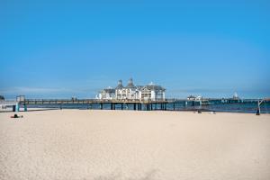a view of a beach with a pier in the background at Fewo am Hochufer - erste Reihe in Ostseebad Sellin