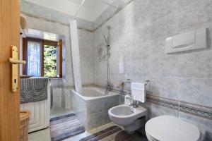 Un baño con inodoro, bañera y lavabo. en Casa Vacanza Le More, en Cares