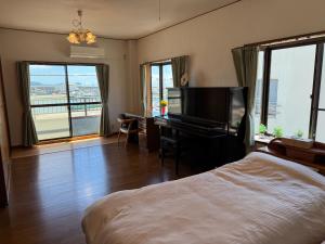 ein Schlafzimmer mit einem Bett und einem Schreibtisch mit einem Klavier in der Unterkunft Namihaya Inn Hanon - Vacation STAY 69722v in Dejima