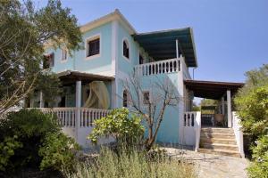 a blue and white house with stairs and trees at Areti Orfeas Apartment 5 in Vasilikos