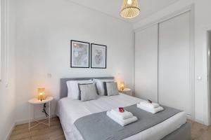 a white bedroom with a bed with towels on it at Formosa Home in Faro