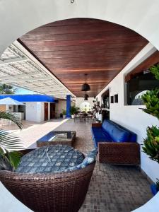 an outdoor patio with a blue couch and chairs at Suites Tropical in João Pessoa