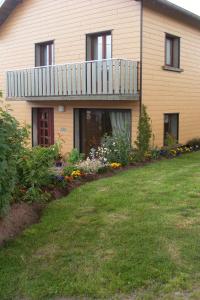 a house with a balcony on top of a yard at Location Vacances Des 4 Vents in Girmont-Val-dʼAjol