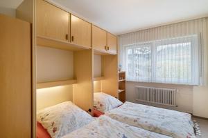 a small bedroom with two beds and a window at Ferienwohnung Matteit in Bad Peterstal