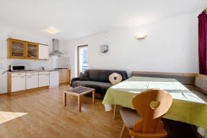 uma sala de estar com uma mesa e um sofá em Apartments Antersi Luis em San Vigilio Di Marebbe