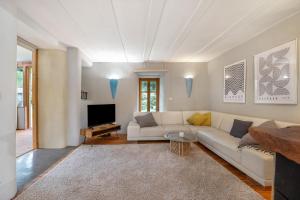 a living room with a white couch and a tv at Alte Mühle in Dernbach in Dernbach