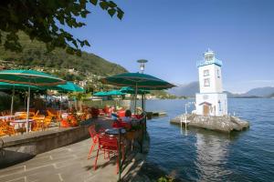 Un faro con mesas y sillas y un faro en Spacious Historic Apartment F1, en Gravedona