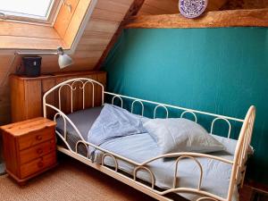 Un dormitorio con una cama y una pared verde. en Villa Kerdrean, en Cléguérec