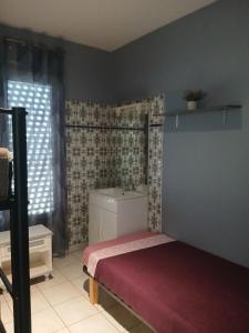 Un dormitorio pequeño con una cama y un lavabo. en Étoile de mer, en Vias