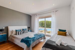 a bedroom with two beds and a view of a pool at A Casa da Vagem in Pernigem +35 photos