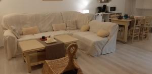 a living room with a white couch and tables at Suite Maraval Chez L'habitant in Trélissac