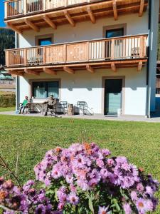 a house with a balcony and flowers in the yard at Cesa Pattis in Campestrin
