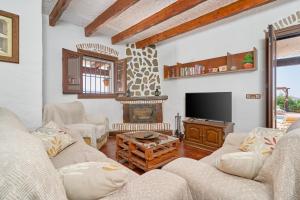 ein Wohnzimmer mit zwei Sofas und einem Fernseher in der Unterkunft Casa Miraflores in Arenas