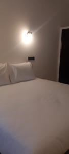 een wit bed met een licht erop bij Lavanda Termas de São Pedro do Sul in Termas de Sao Pedro do Sul +17 foto's