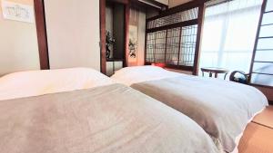 Ένα ή περισσότερα κρεβάτια σε δωμάτιο στο Wahori - A Traditional Japanese Guesthouse