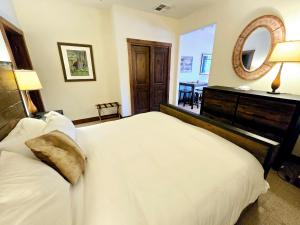 a bedroom with a large white bed and a mirror at Whitefish Downtown Suites in Outback Mobile Home Settlement