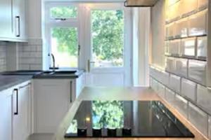 eine Küche mit einem Glastisch in der Mitte in der Unterkunft 2 Bed - Sleeps 6 - Parking - Town Centre in Reigate