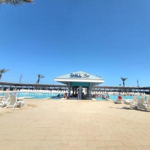 a resort with a pool and chairs and a pier at Paradise Vibes in Bolivar Peninsula